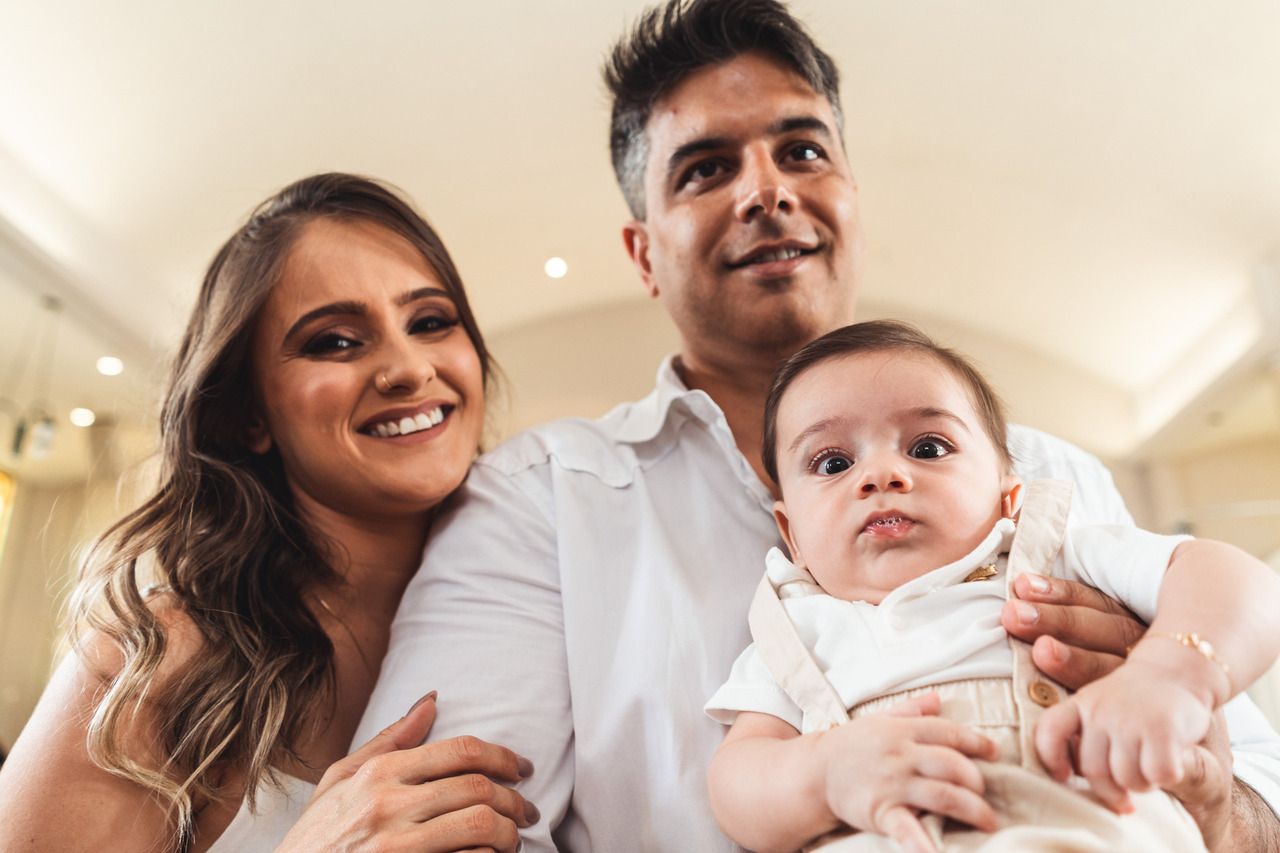 Pais acolhem o bebê no colo durante a celebração