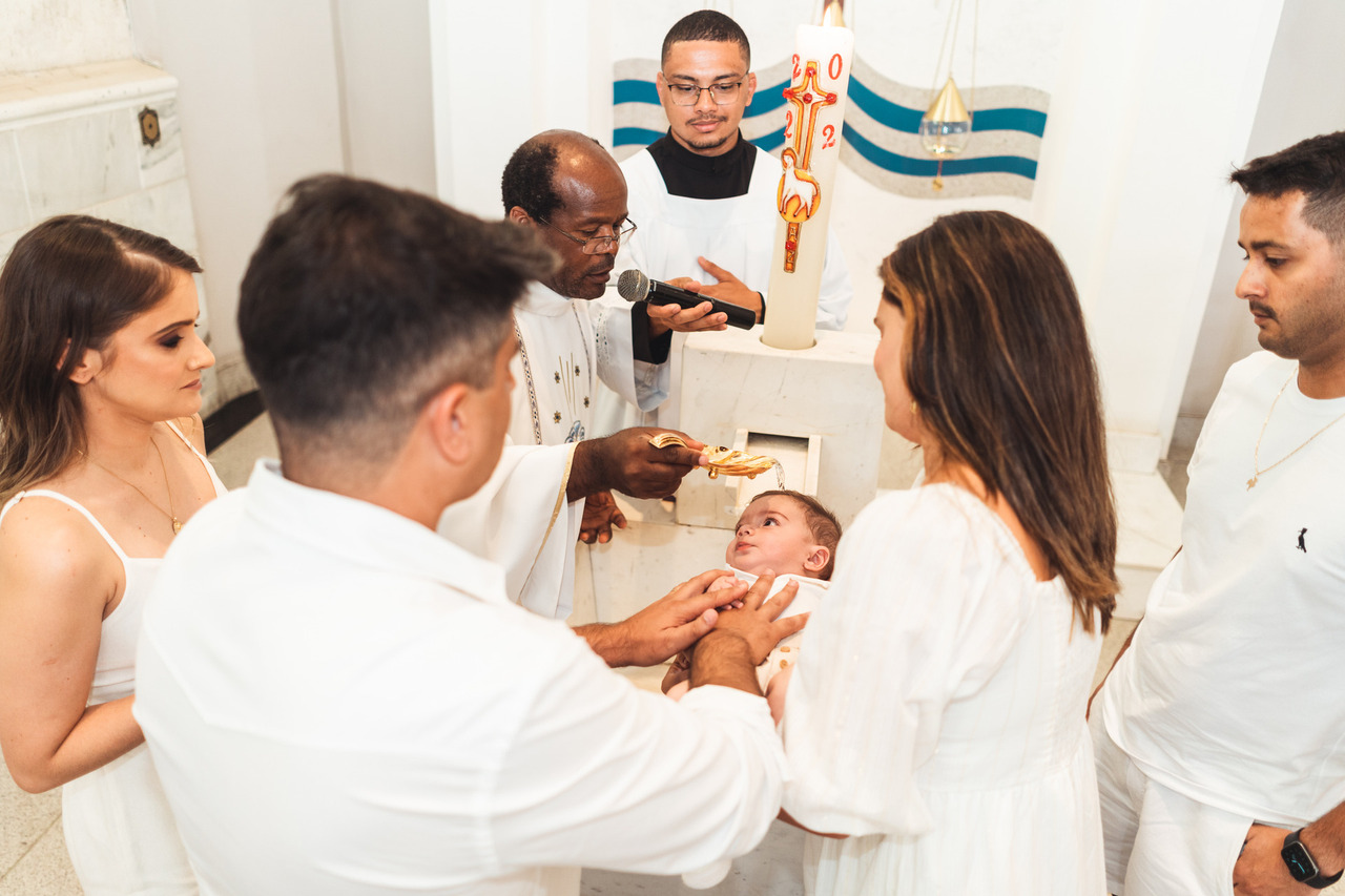 Celebrante abençoa o bebê junto à família