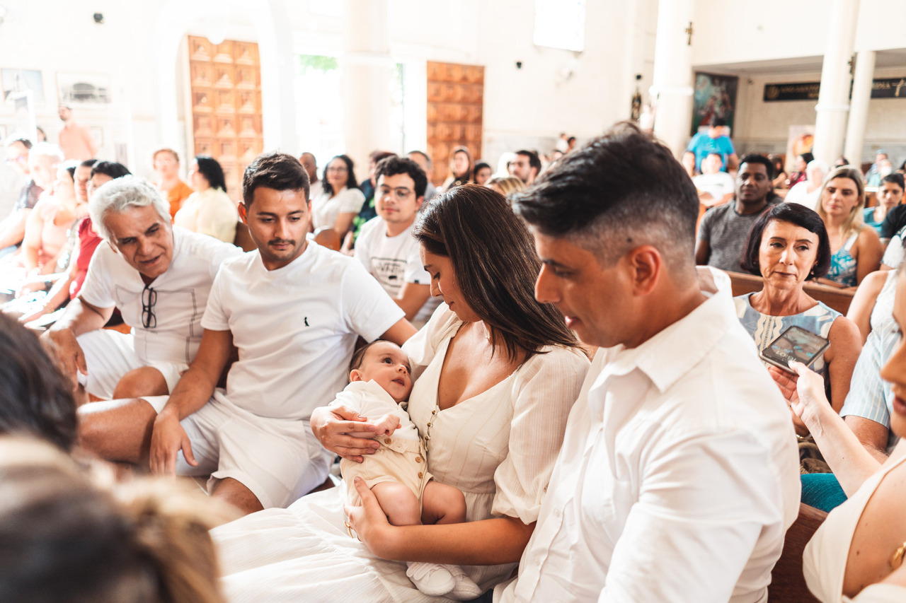 Familiares se aproximam do bebê durante a celebração